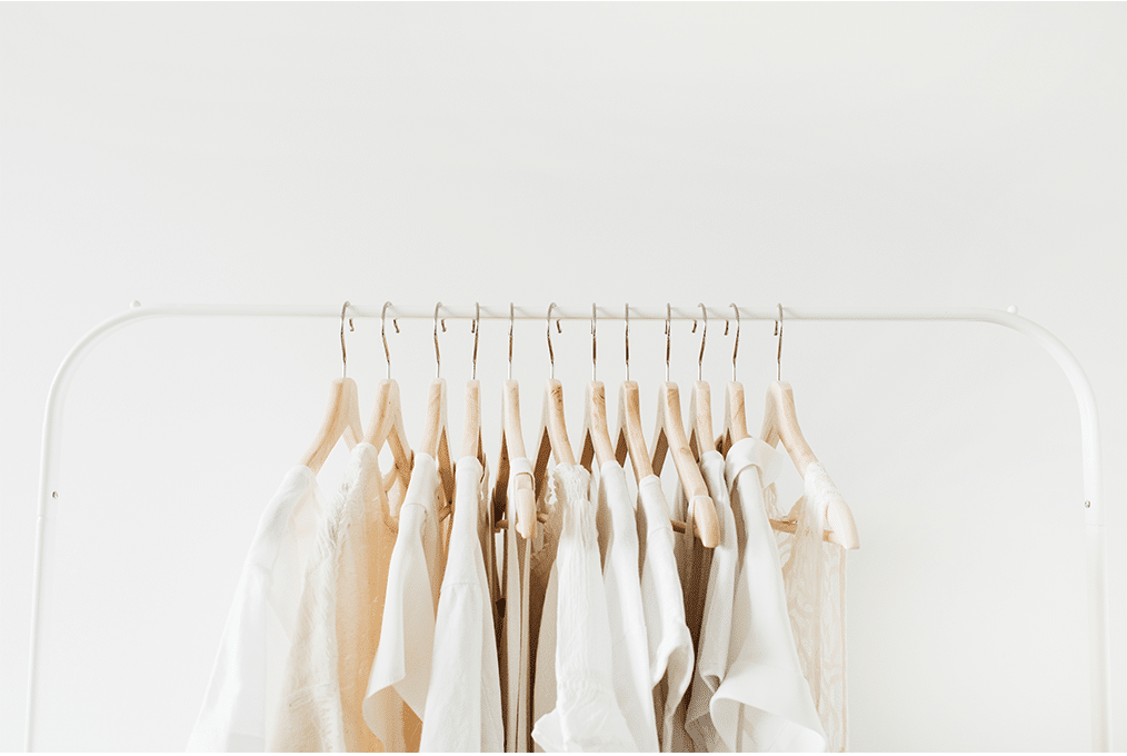 White and beige shirts hanging on a clothing rack