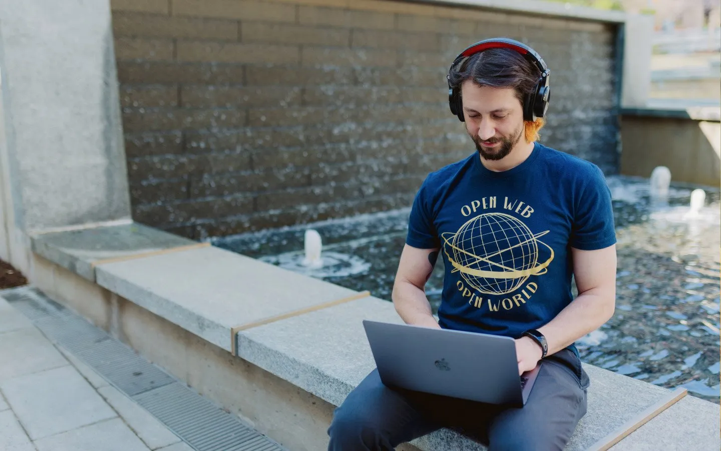 developer sitting at laptop outside