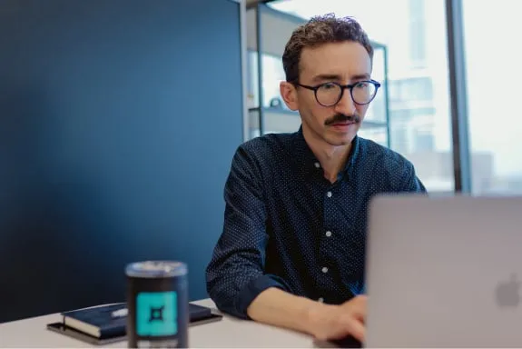 Man with glasses looking at laptop screen