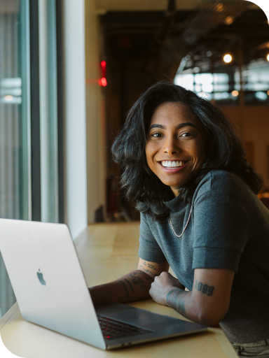 person smiling at laptop working on WP Engine Headless WordPress team